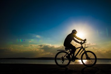 Genç adam bisikletçi siluet 