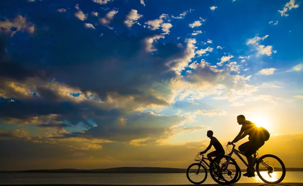 Silhouettes of cyclists on coast. — Stock Photo, Image