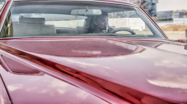 Жінка сидить всередині червоної машини — стокове фото