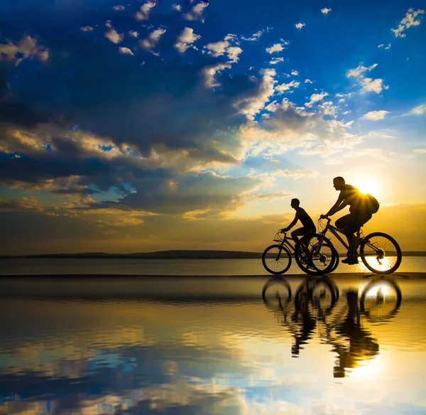 Silhouetten von Radfahrern an der Küste. — Stockfoto