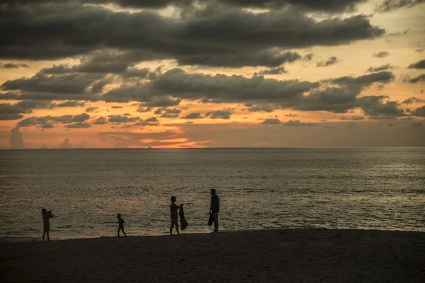 Silhouetten van gelukkige familie op strand — Stockfoto