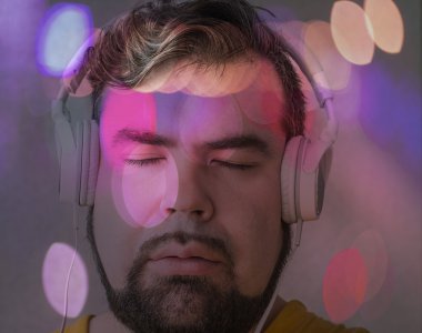 gri doku arka planda müzik sakin dinlerken kapalı gözlü yakışıklı esmer hipster çocuk portresi