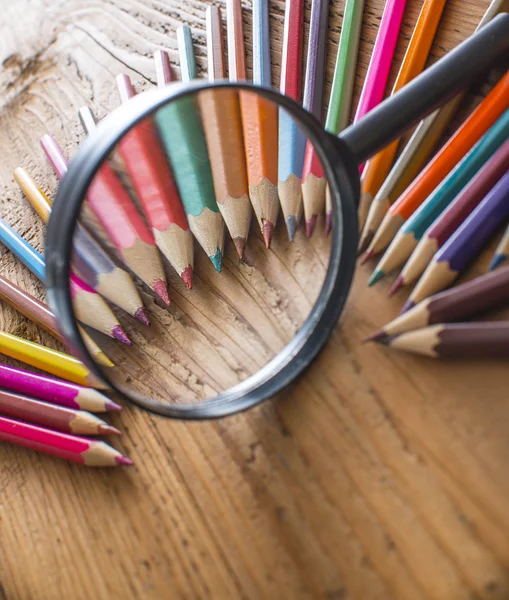 Pencils under magnifying glass — Stock Photo, Image