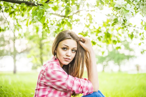 Girl sitting down under tree — Stock Photo, Image