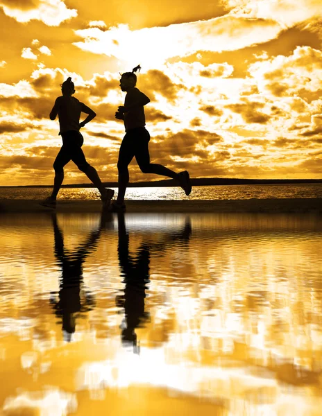 silhouettes of two women running