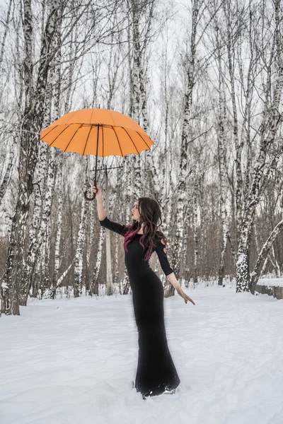 Дівчина з парасолькою стоїть на снігоході — стокове фото