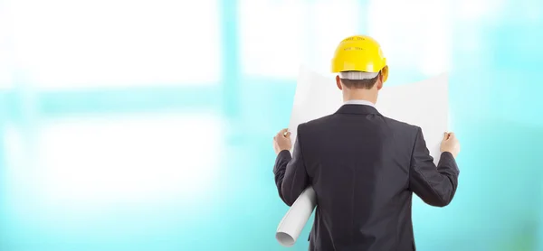 engineer with yellow helmet and holding plan