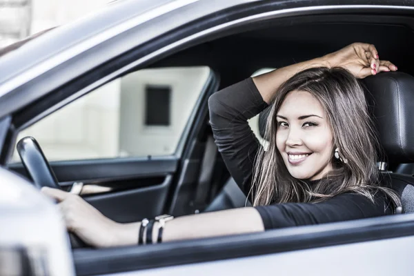 Kobieta z rąk na kierownicy w samochodzie — Zdjęcie stockowe