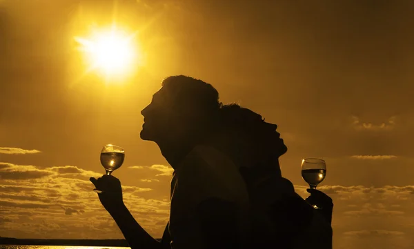 Silhouettes of Man and woman with  glasses of champagne