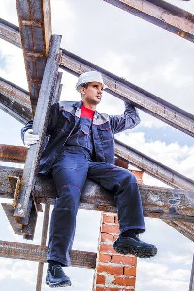 Full length body portrait of worker on a roof frame, Under construction on blue summer sky background with clouds