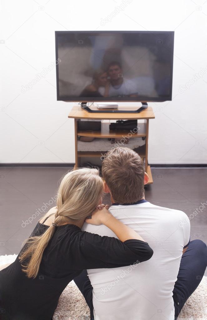  couple watching  tv set