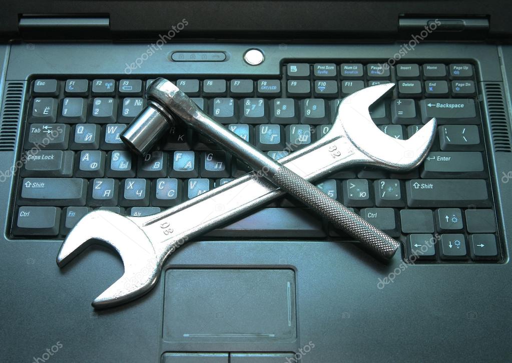 Background of  Two metal spanners on black  laptop keyboard