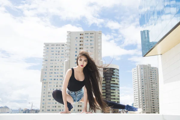 Танцующая брюнетка азиатка на крыше — стоковое фото