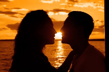 Sunset beach arka plan üzerinde çift öpüşme siluet. 