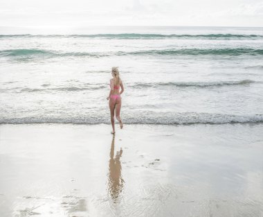 Sabah sis bir plajda kaçan genç güzel sarışın kız. 