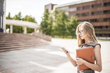 Cep telefonu ve tutun dijital tablet bilgisayar kullanarak genç iş kadını