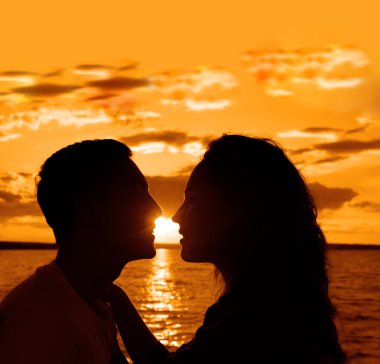 Sunset beach arka plan üzerinde çift öpüşme siluet. 
