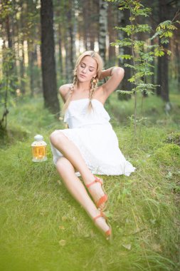 ormanda oturan genç sarışın kadın