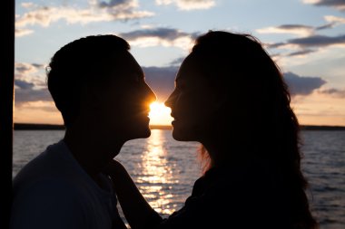 Sunset beach arka plan üzerinde çift öpüşme siluet. 