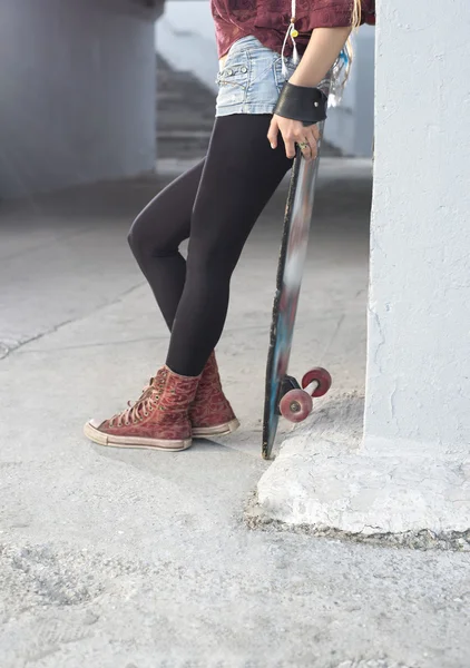 Oman poserar med skateboard — Stockfoto