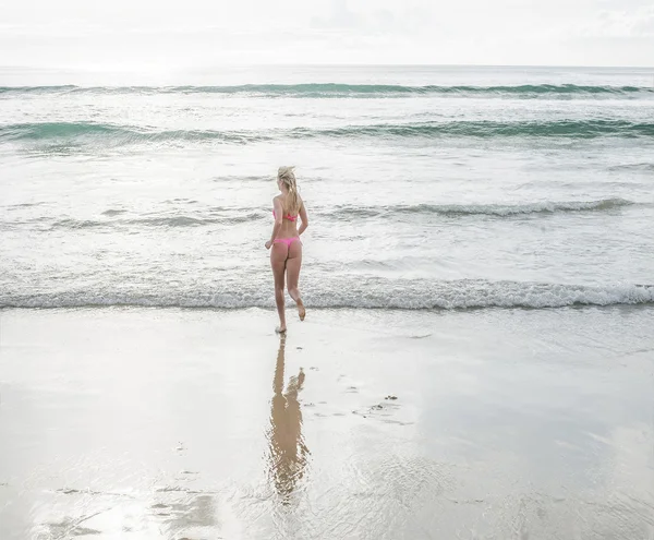 年轻美丽的金发女孩在晨雾中在海滩上奔跑 — 图库照片