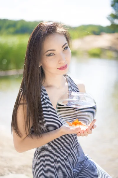 Fishbowl em mãos de menina asiática jovem — Fotografia de Stock