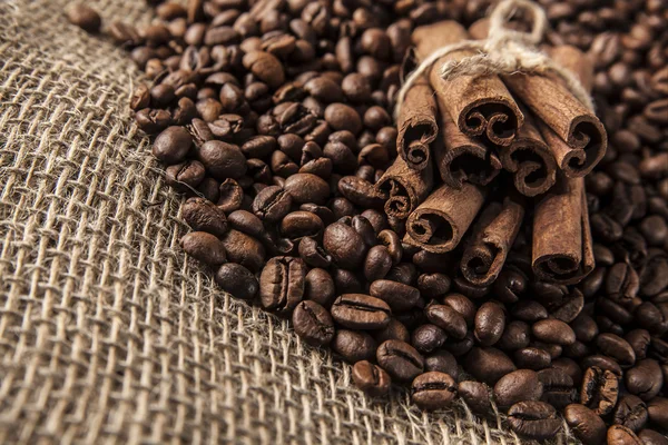 Grãos de café, canela sobre pano de saco — Fotografia de Stock