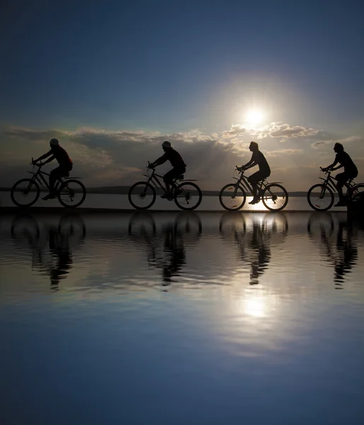 Freunde auf Fahrrädern bei Sonnenuntergang. — Stockfoto