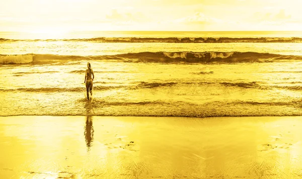 Mulher em maiô vai para o oceano — Fotografia de Stock