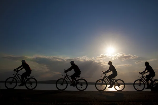 Vänner på cyklar i solnedgången. — Stockfoto