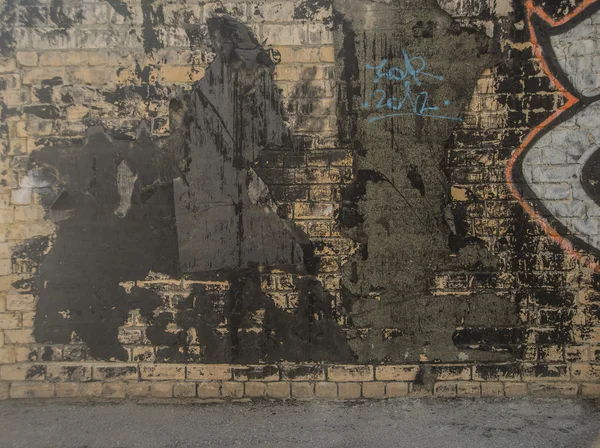 Грязная кирпичная стена с граффити — стоковое фото