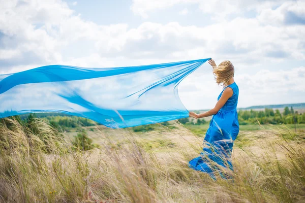 Girl with flying blue cloth — Stock Photo, Image