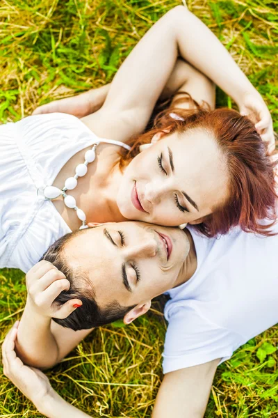 向上查看 一个幸福的年轻夫妇的肖像躺在草地上的公园 — 图库照片