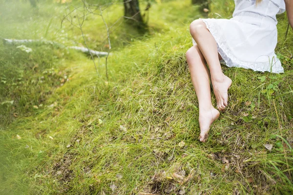 Çıplak bacaklar taze yeşil çimenlerin üzerinde ben