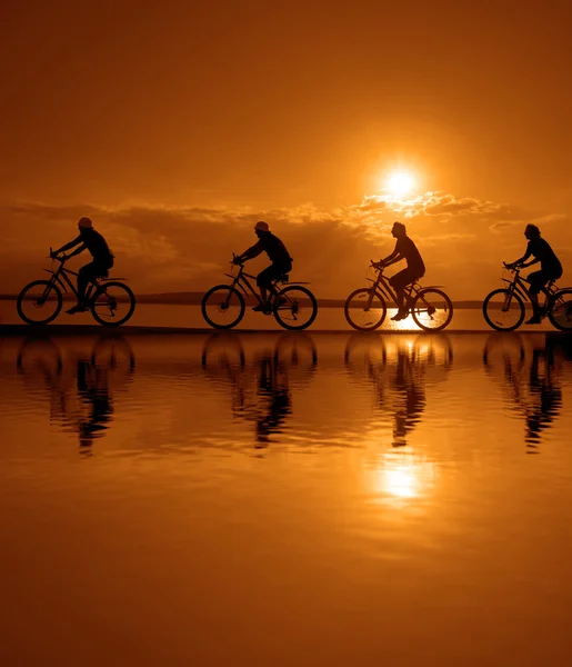 Freunde auf Fahrrädern bei Sonnenuntergang. — Stockfoto