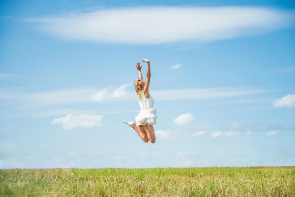 Woman Jumping for Joy on a Grass Stock Picture
