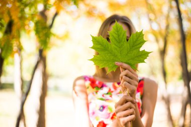 Akçaağaç yaprağı elinde tutan kız