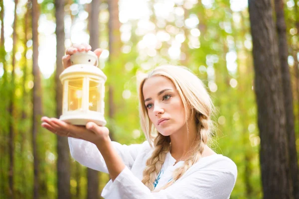 Mulher segurando lâmpada com vela para dentro — Fotografia de Stock