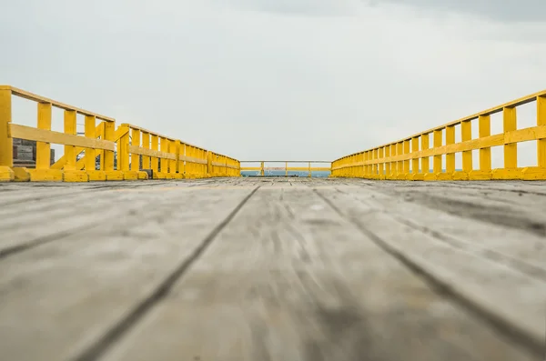 Suelo de madera con valla amarilla — Foto de Stock