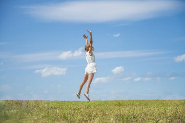 Woman Jumping for Joy on a Grass