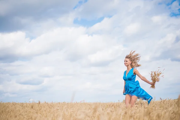 Portrait of romantic slim woman running across wheat field weari Stock Photo