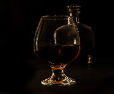 Glass of cognac and a bottle clipart