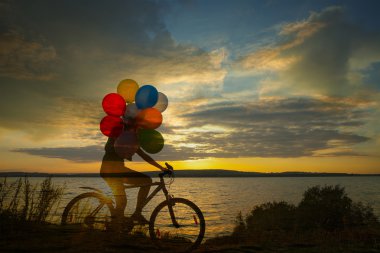 Kız hava balonu tutan bisiklet üzerinde 