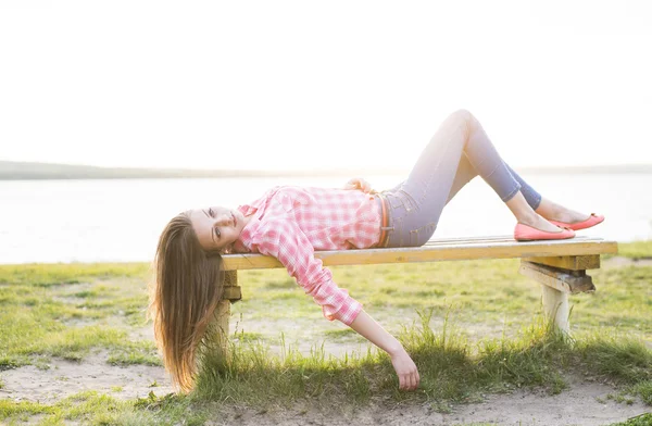 Frau auf der Bank liegend — Stockfoto