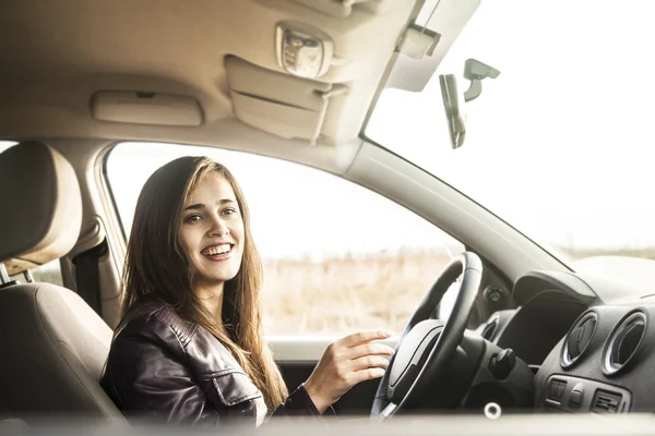 woman in car holding steering wheel