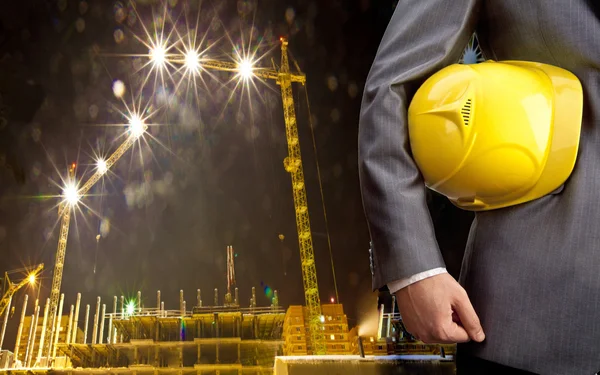 Engenheiro segurando capacete amarelo — Fotografia de Stock