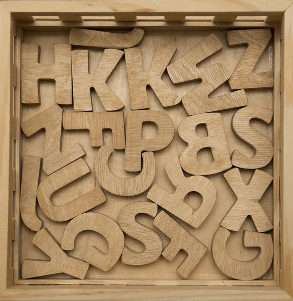 Willekeurige houten letters op een schoolbord oppervlak opgestapeld. instellen van hout — Stockfoto