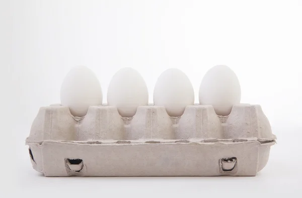 Huevos blancos yacen en caja de dibujos animados — Foto de Stock