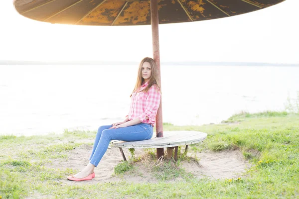 Young woman sitting on bench — Stock Photo, Image