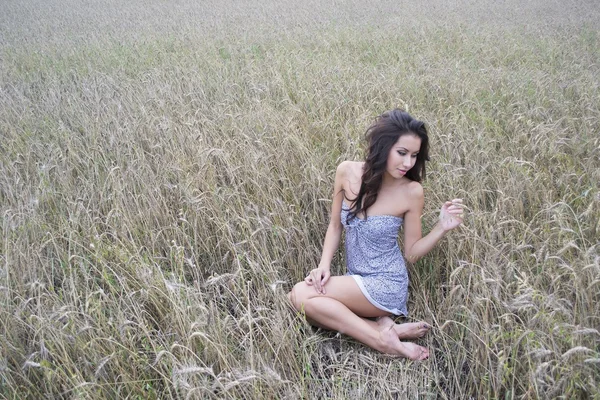 Donna seduta sul campo di grano — Foto Stock